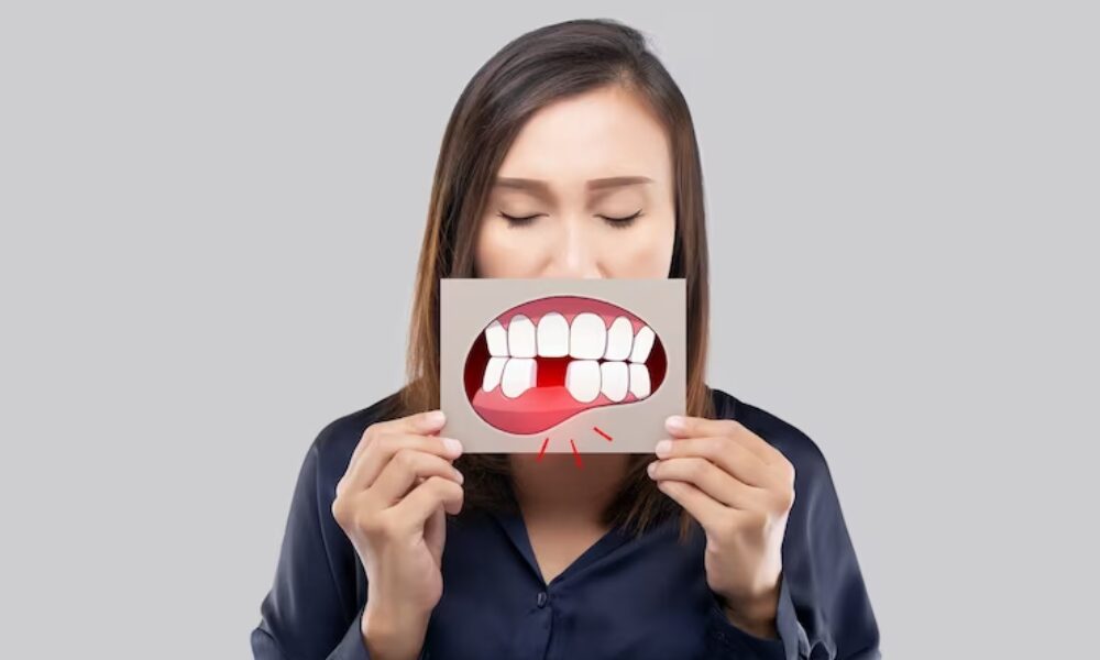 Woman holding a drawing of a painful missing tooth in front of her mouth.